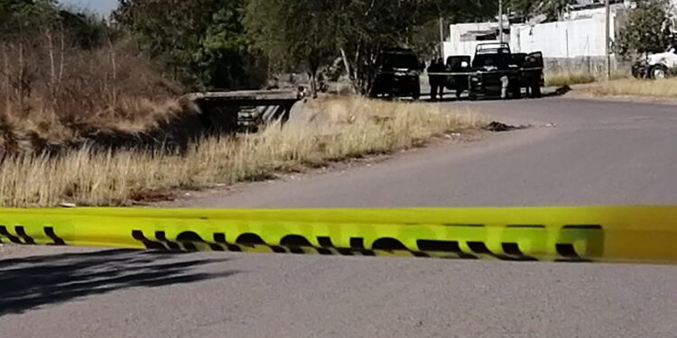 Localizan a un hombre asesinado a balazos en canal de aguas pluviales